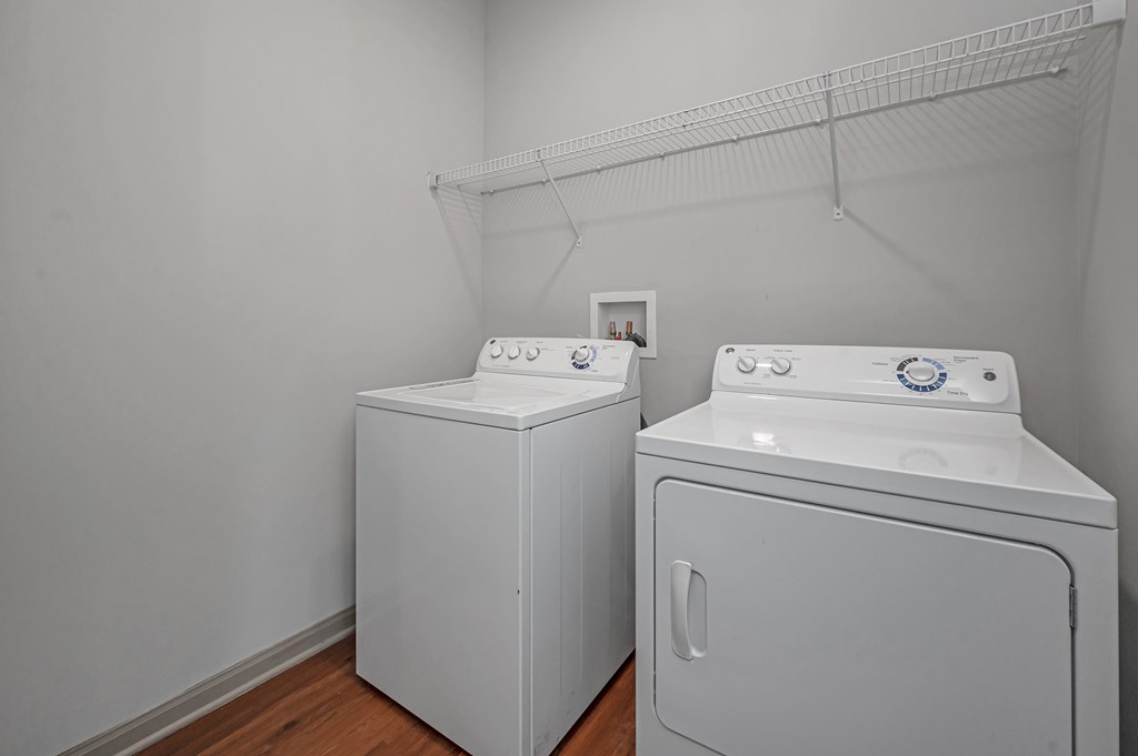 Two white front loading washing machines in a laundry room.